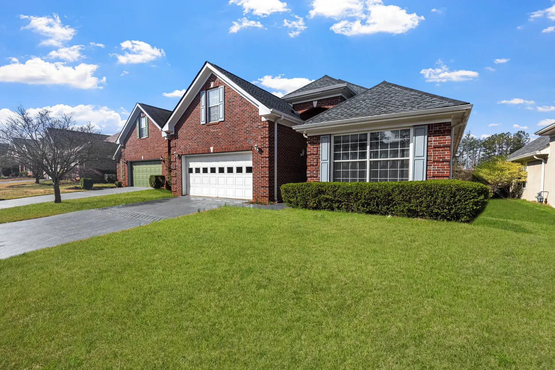 Freshly mowed and edged front lawn beside a clean driveway.