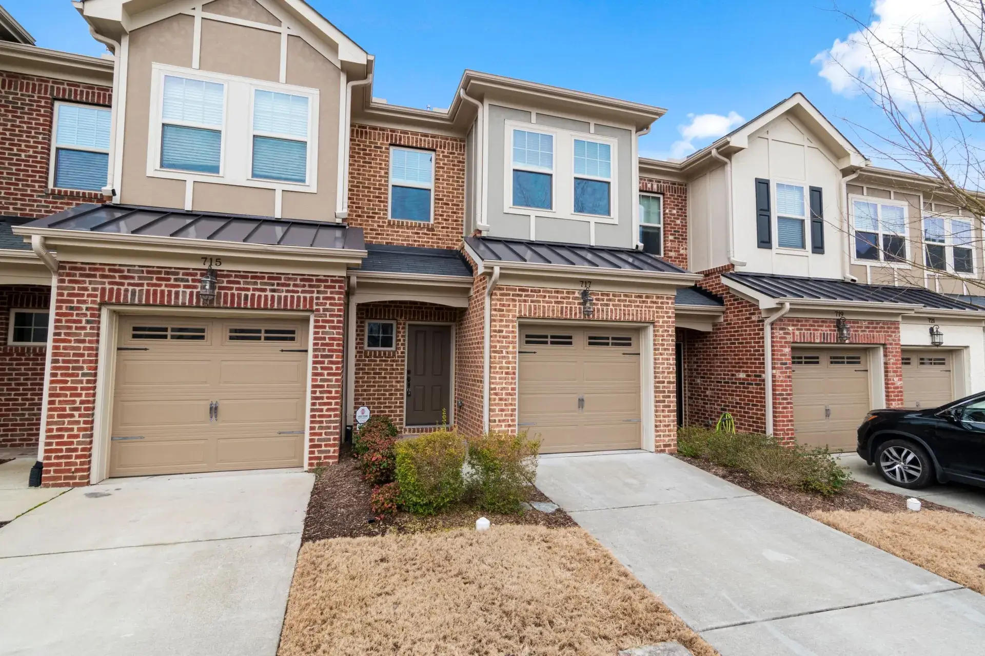 Row of brick townhomes with small front lawns.